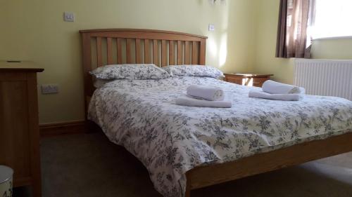 een slaapkamer met een bed met 2 kussens erop bij Courtbrook Farm in Exeter