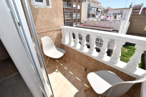 a balcony with two chairs and a railing at HB Torrevieja in Torrevieja