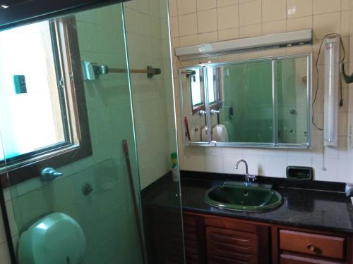 y baño con lavabo y ducha con espejo. en Casa São Sebastião, en São Sebastião