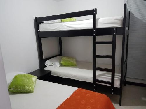 a room with two bunk beds and a bed at 3'min del Parque del Café Apto y Piscina in Montenegro
