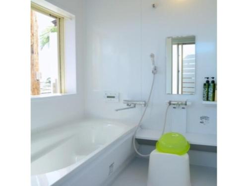 a white bathroom with a tub and a green stool at Orizon - Vacation STAY 21783v in Minamiboso