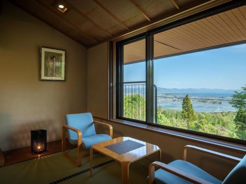 a room with a chair and a table and a large window at Lake View Inaedaiso - Vacation STAY 34438v in Inawashiro