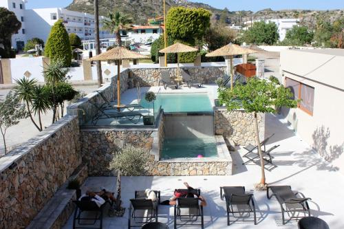 a resort with a swimming pool and people sitting in chairs at John Mary in Faliraki