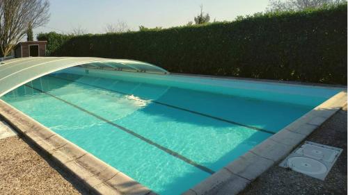 une piscine avec de l'eau bleue dans une cour dans l'établissement Maison la grande serre, à Blaslay