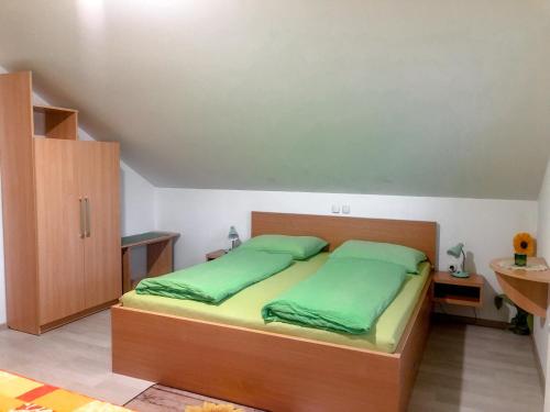 a bedroom with a bed with green sheets at Apartments Sončnica in Moravske Toplice