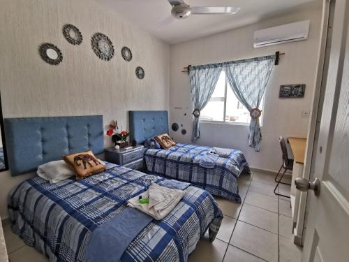 1 dormitorio con 2 camas y ventana en Cozy house with swimming pool and chill place., en Playa del Carmen