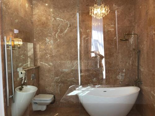 a bathroom with a toilet and a tub and a sink at Apartment Tamarioni in Tbilisi City