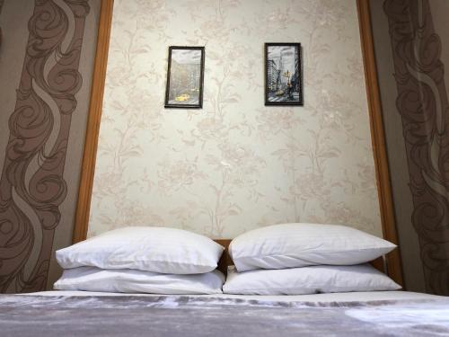 two pillows on a bed in a bedroom with wallpaper at Готель "Опалковий Замок" in Kyiv