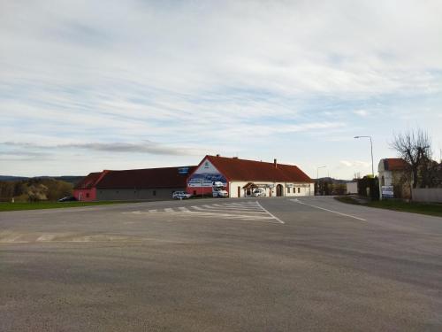 a building with a parking lot in front of it at Penzion Janoušek Motorsport Český Krumlov in Přísečná