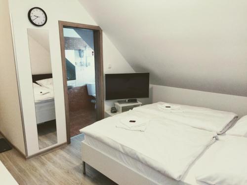 a bedroom with a white bed and a mirror at Penzion Janoušek Motorsport Český Krumlov in Přísečná
