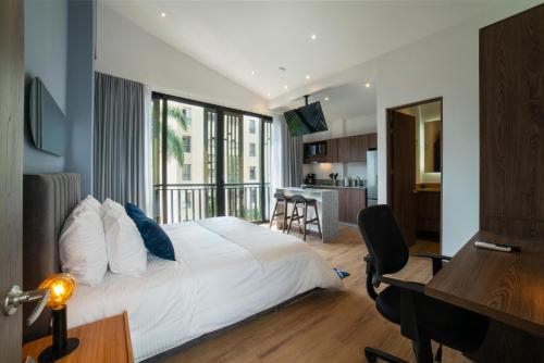 Un dormitorio con una cama y un escritorio y una cocina. en Cali River Suites by Yellowkey Capital, en Cali