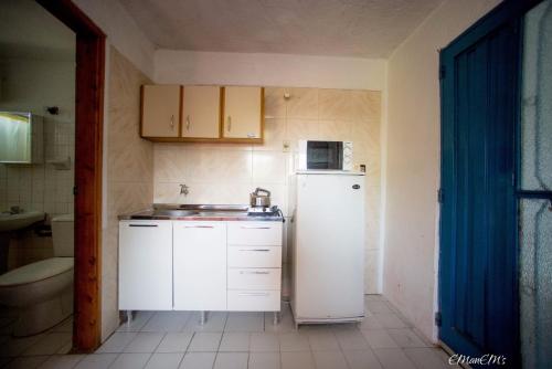 una pequeña cocina con nevera y microondas en Apartamentos Oyster, en Atlántida
