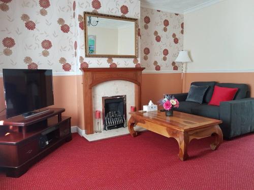 sala de estar con sofá y chimenea en Delight Marvel-Derby House at Maidstone en Maidstone