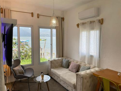 a living room with a couch and a view of the ocean at VENICE by luxury Atitlan in San Pedro La Laguna