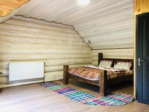 1 dormitorio con 1 cama en una pared de madera en У ВІТИ котедж4, en Synevyrsʼka Polyana