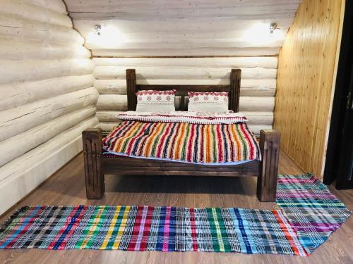 un letto con due cuscini in una camera in legno di У ВІТИ котедж4 a Synevyrsʼka Polyana