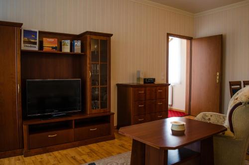 a living room with a flat screen tv and a table at Hotel Meereswelle - Anno 1875 in Ahlbeck