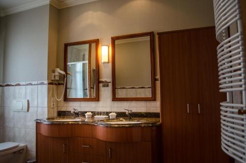 a bathroom with two sinks and a mirror at Hotel Meereswelle - Anno 1875 in Ahlbeck