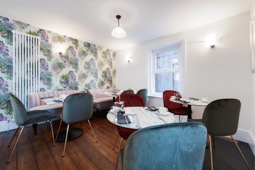 a dining room with tables and chairs and floral wallpaper at Florence House Boutique Hotel and Restaurant in Portsmouth
