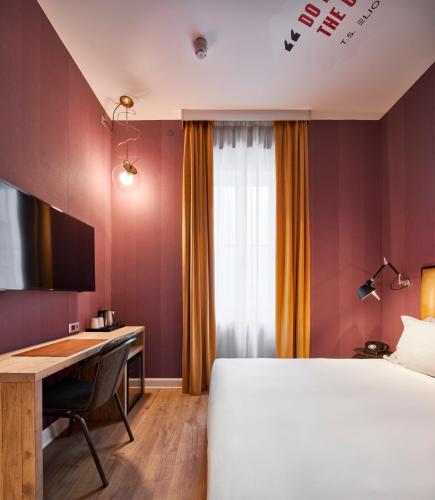 a hotel room with a bed and a desk at The Modernist Hotel in Trieste