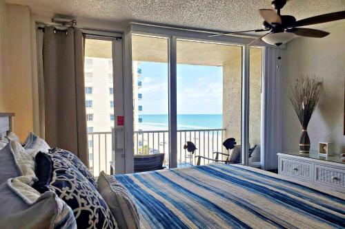 a bedroom with a bed and a view of the ocean at Pirates Cove Condo Unit #704 in Daytona Beach Shores