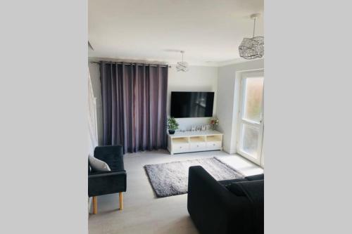 uma sala de estar com um sofá e uma televisão em Modern House in Bournemouth town centre em Bournemouth