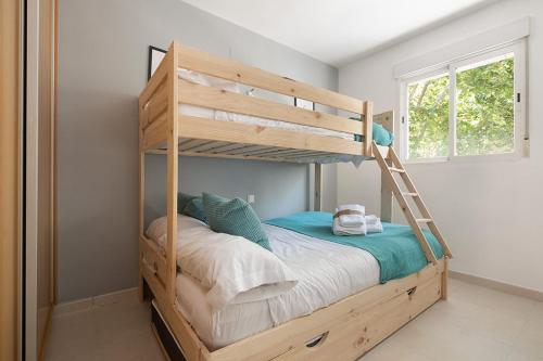 a wooden bunk bed with a ladder in a room at Toros Apartamentos in Palma de Mallorca