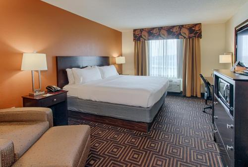 a hotel room with a bed and a television at Holiday Inn Knoxville West - Cedar Bluff Rd by IHG in Knoxville