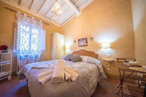 a bedroom with a bed with towels on it at Il Giardino Segreto B&B in Volterra