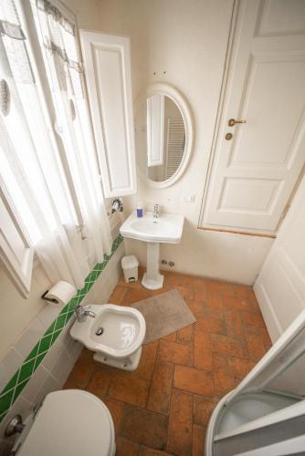 a bathroom with a sink and a toilet and a mirror at Il Giardino Segreto B&B in Volterra
