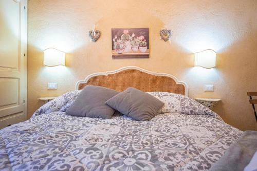 a bedroom with a bed with two pillows and two lights at Il Giardino Segreto B&B in Volterra