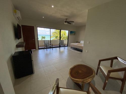 a room with a bedroom and a bed and a table at Cuxos Hotel Beachfront in Isla Mujeres