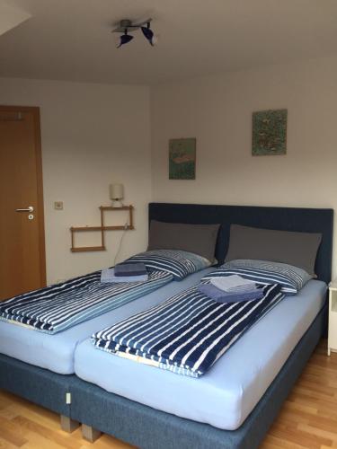 a bedroom with a bed with a blue and white comforter at Kleine Wohnung mit Terrasse in Dülmen