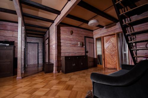 a living room with wooden walls and wooden floors at Dworek Ogrodniki, całoroczny dom na wyłączność, basen, sauna, las, staw rybny, altana grillowa, ognisko, pianino, kominek, piec chlebowy, duża ogrodzona posesja in Tuczna