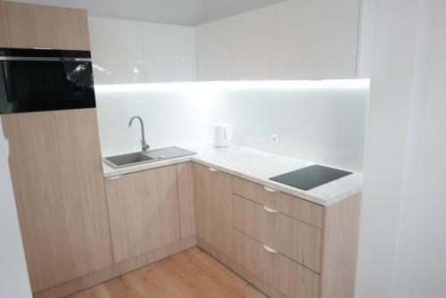 a kitchen with a sink and a microwave at Apartamenty Marco Polo in Dziwnówek