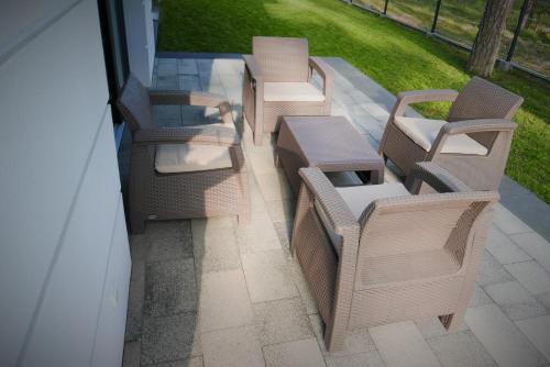 a group of chairs and tables on a patio at Apartamenty Marco Polo in Dziwnówek