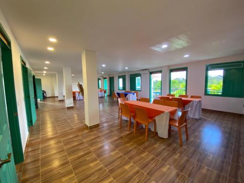 a dining room with tables and chairs and windows at Hotel Campestre Paraiso Cafetero in Montenegro