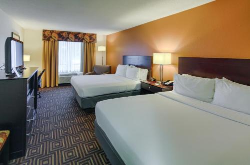 a hotel room with two beds and a flat screen tv at Holiday Inn Knoxville West - Cedar Bluff Rd by IHG in Knoxville