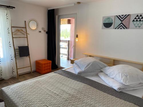a bedroom with a bed with two pillows and a window at Pensiunea Bradet - Padis in Padis