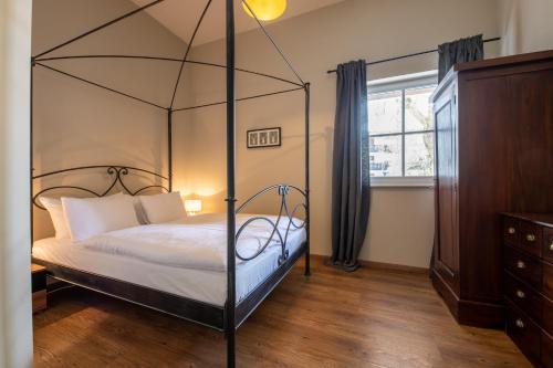 a bedroom with a four poster bed and a window at Haus Ludwig Murmeltier in Garmisch-Partenkirchen