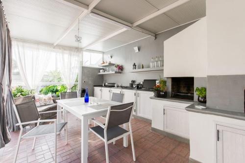 una cucina bianca con tavolo e sedie bianchi di La Casa del Viaggiatore a Milazzo