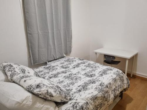 Ce lit se trouve dans un dortoir doté d'une table et d'une fenêtre. dans l'établissement Appartement T3, cosy, climatisé, équipé avec goût, à Avignon