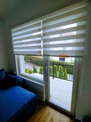 a bedroom with a window with blinds on a balcony at MK Zlatibor in Zlatibor