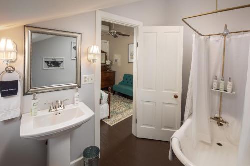 uma casa de banho com um lavatório, um chuveiro e uma banheira em Aldrich Guest House em Galena