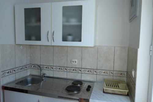 a kitchen with white cabinets and a sink at Aпартаменты Влаович in Igalo