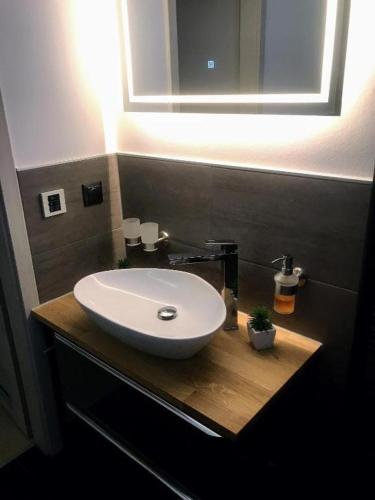 a bathroom with a white sink and a mirror at SALZHAUSBLICK BUSINESS APARTMENTS - Zentrale Lage am Salzhaus - MwSt-Rechnung verfügbar in Zittau