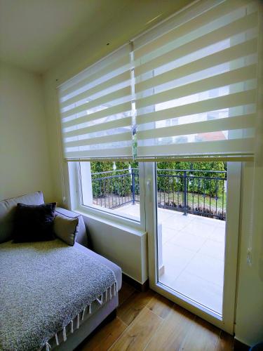 a bedroom with a large window with a blind at MK Zlatibor in Zlatibor