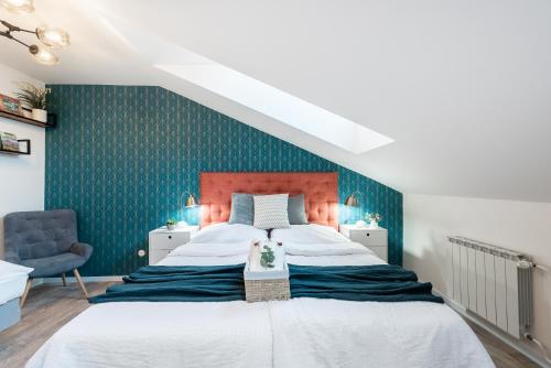 a bedroom with a large bed and a blue wall at Penzion Dubina in Litoměřice