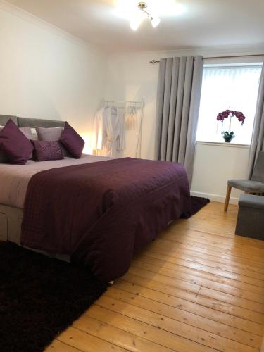 a bedroom with a large bed and a window at ACE Largs Ground Floor Apartment with Garden in Largs