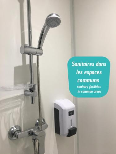 a shower in a bathroom with a sign that says servicesds less expenses commutes at HôtelF1 Angoulême in Champniers